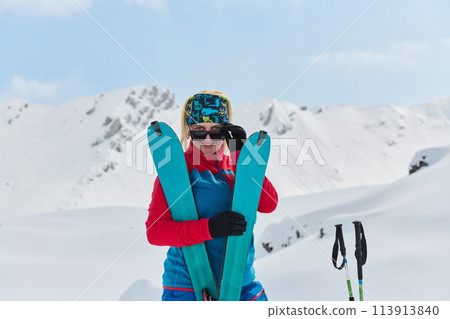 A professional woman skier rejoices after successfully climbing the snowy peaks of the Alps A professional woman skier rejoices after successfully climbing the snowy peaks of the Alps 113913840