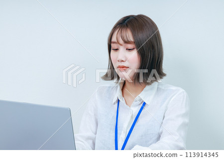 A young female staff member operating a PC 113914345