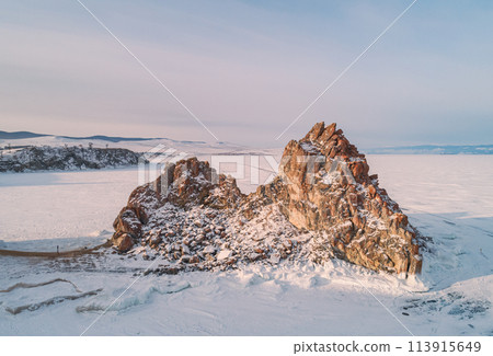 Aerial shot of a Shamanka rock on Olkhon island at sunset. Winter landscape. Popular touristic destination. Natural landmark. Panoramic view 113915649
