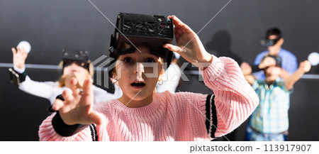 Tween girl using vr headset goggles to play exciting game Tween girl using vr headset goggles to play exciting game 113917907