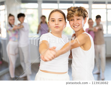 Girl dances waltz with male boy teen partner during choreography lesson 113918082