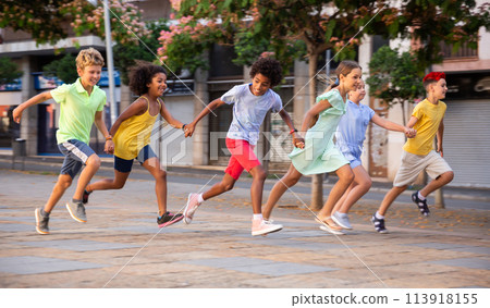 Happy tween friends running together on summer city street Happy tween friends running together on summer city street 113918155