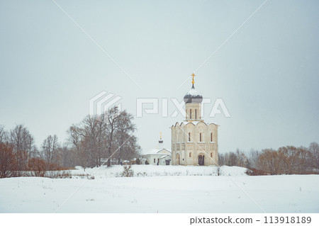 a church in winter in the middle of a snow-covered field 113918189