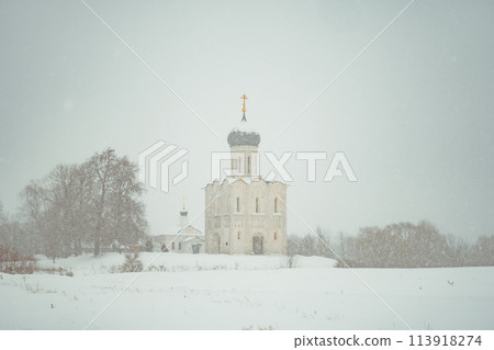 a church in winter in the middle of a snow-covered field 113918274