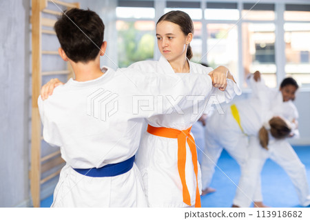 Sparring during karate training of children of different nationalities in sport gym Sparring during karate training of children of different nationalities in sport gym 113918682