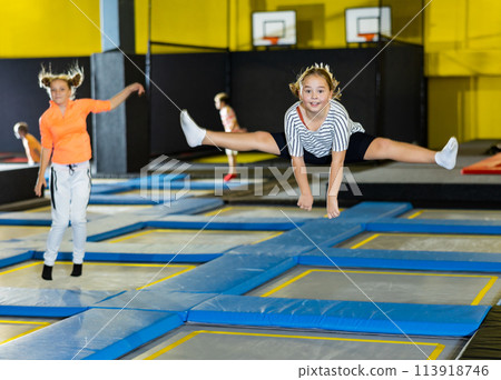 Girl jumping on trampoline park in sport center 113918746