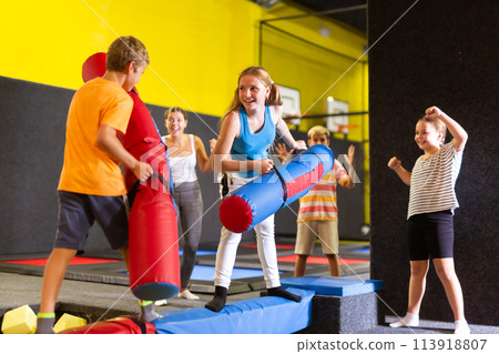 Teen girl having fun on battle beam with preteen brother Teen girl having fun on battle beam with preteen brother 113918807