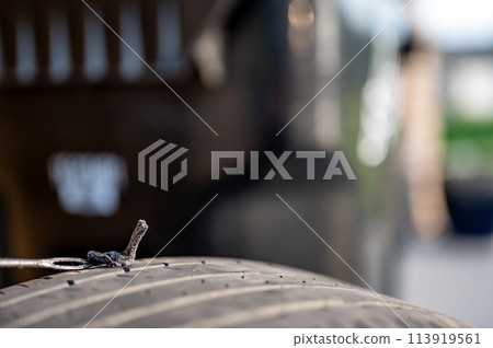 Repair plug being inserted to patch a nail tire puncture Repair plug being inserted to patch a nail tire puncture 113919561