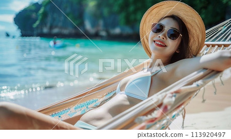 Summer travel concept, Happy traveler young woman with bikini relax in hammock on beach. 113920497