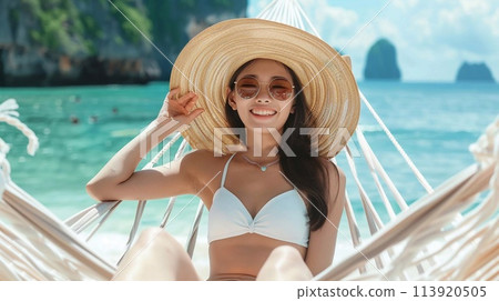 Summer travel concept, Happy traveler young woman with bikini relax in hammock on beach. 113920505