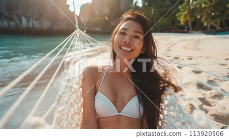 Summer travel concept, Happy traveler young woman with bikini relax in hammock on beach. 113920506