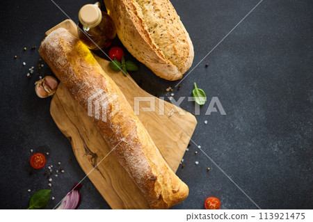 freshly baked bread on wooden cutting board on dark table freshly baked bread on wooden cutting board on dark table 113921475