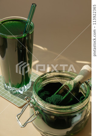 Natural organic green spirulina algae powder drink on neutral beige background. Chlorella seaweed vegan superfood cocktails smoothie supplement source and detox drinking. Innovative ingredient Natural organic green spirulina algae powder drink on neutral beige background. Chlorella seaweed vegan superfood cocktails smoothie supplement source and detox drinking. Innovative ingredient 113922365