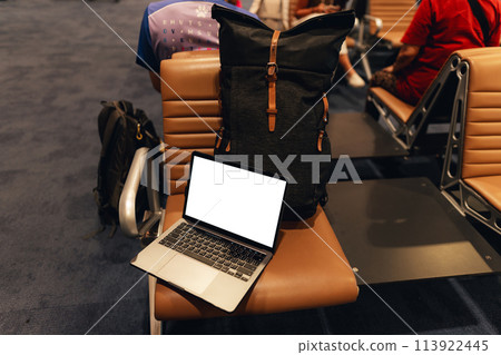 A laptop with blank screen on chair at airport 113922445