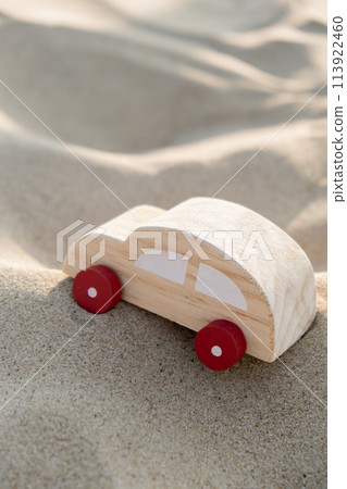 Wooden toy car on sandy beach background. Eco-friendly travel, reduce carbon footprints, environmental impact, Conscious Traveler, Environmentally Friendly, responsible traveler Eco-car concept World 113922460