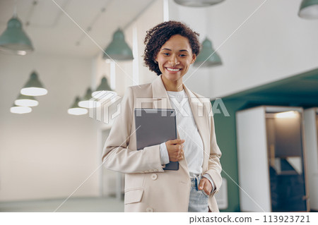 Smiling business woman with digital tablet standing on modern office background and looks camera 113923721