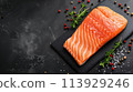 raw salmon steak on black slate 113929246