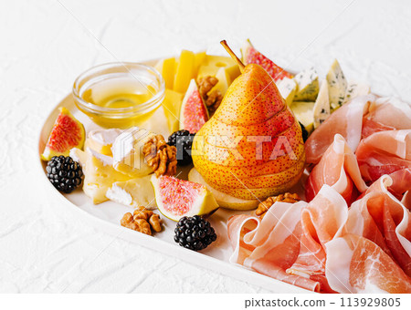 Italian antipasto with prosciutto, cheeses, nuts and fruits Italian antipasto with prosciutto, cheeses, nuts and fruits 113929805