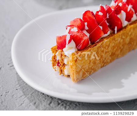 Sweet cake with strawberries on plate 113929829