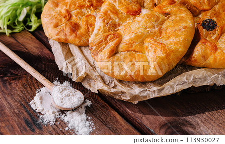 Cooking traditional pies with cabbage on wooden board Cooking traditional pies with cabbage on wooden board 113930027