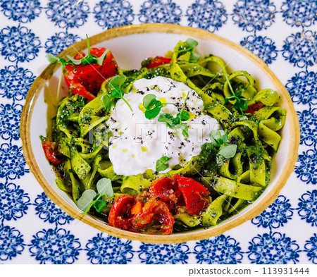 Plate of delicious pasta with pesto sauce close up 113931444