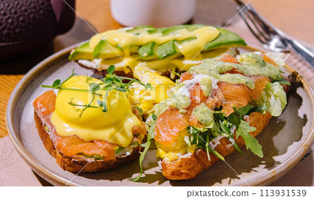 Toast and croissant with salmon, poached egg and avocado 113931539