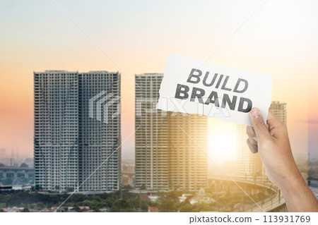 Human hand showing ripped paper with build brand text 113931769