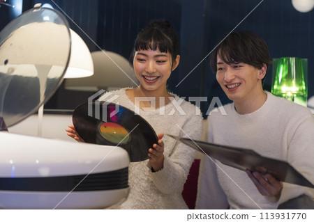 Young men and women listening to records 113931770