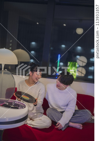Young men and women listening to records Young men and women listening to records 113931857