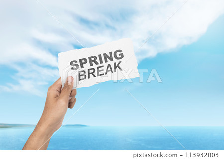 Summer break is shown man hand holding white paper with text against the beautiful blue sky. 113932003