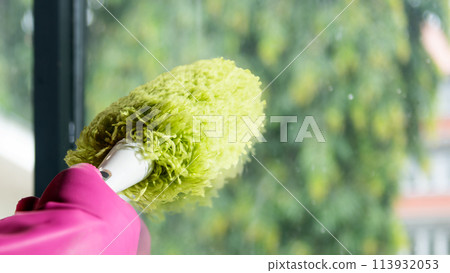 Human hand in protective glove wiping using a duster 113932053