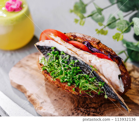 Mackerel fish sandwich on wooden board Mackerel fish sandwich on wooden board 113932136