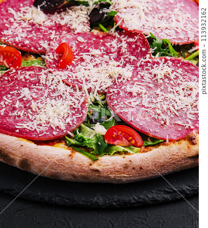 Delicious pizza with salami, arugula and tomatoes 113932162