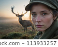 A deer peeking through the bushes, with a young woman in the background. The scene captures a moment of wildlife encounter. 113933257