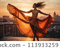 A dancer twirls on a rooftop at sunset, her dress flowing. The city skyline is the backdrop to her graceful motion. 113933259