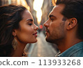 A couple shares a romantic gaze on an illuminated street. Their close proximity suggests an intimate connection. 113933268