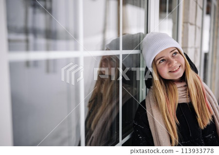 Portrait of a teenage girl at the windows of her home. 113933778