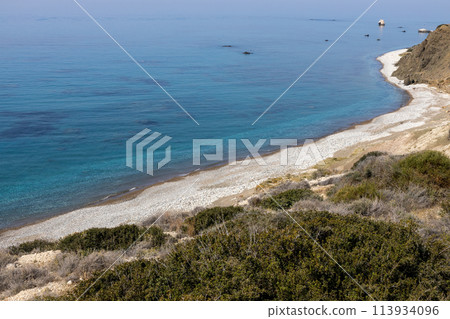 Classic Cypriot Pebble Beach. Mediterraneans azure waves gently kiss the shore. 113934096