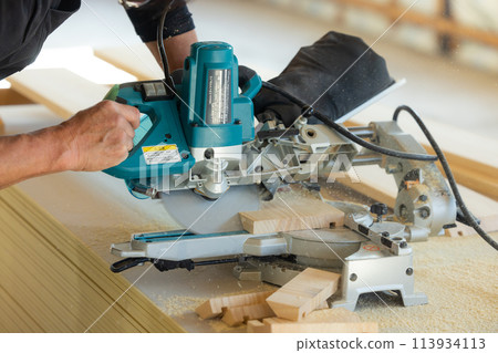 Worker cutting wood 113934113
