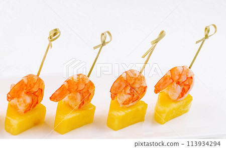 Canapes with shrimp and pineapple on plate 113934294