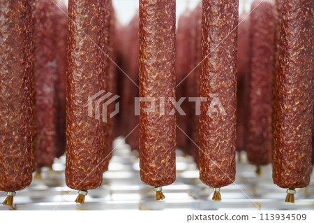 Salami sausage production at a meat factory. Pork and beef sausage salami industry Salami sausage production at a meat factory. Pork and beef sausage salami industry 113934509