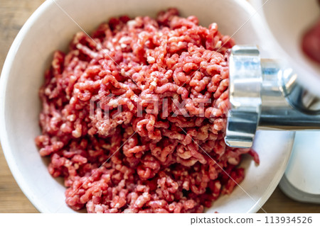 Minced meat and electric meat grinder. Cooking beef minced in the kitchen with an electric grinder 113934526