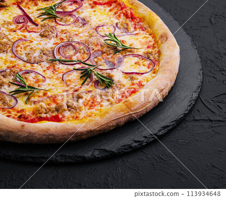 Pizza with tuna and red onion on stone cutting board Pizza with tuna and red onion on stone cutting board 113934648