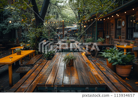 A long wooden table positioned under the shade of a tree in a natural setting 113934657