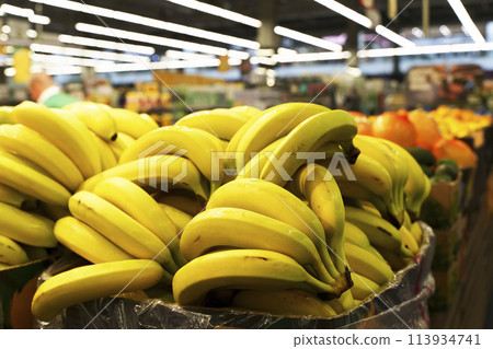 Bananas in supermarket on the counter. Farm bananas fruits and vegetables on sale in a store Bananas in supermarket on the counter. Farm bananas fruits and vegetables on sale in a store 113934741
