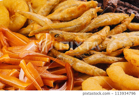onion rings, fried smelt, pork ears close up 113934796