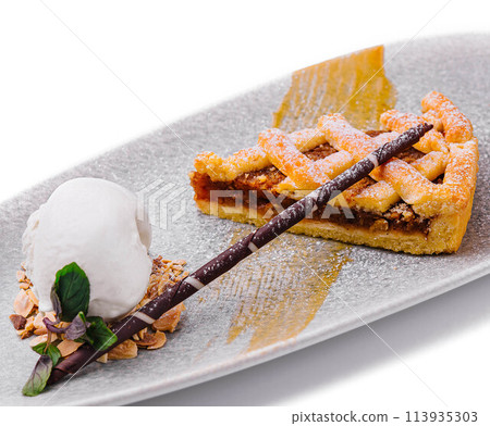 A slice of a pecan pie with ice cream and pecans A slice of a pecan pie with ice cream and pecans 113935303