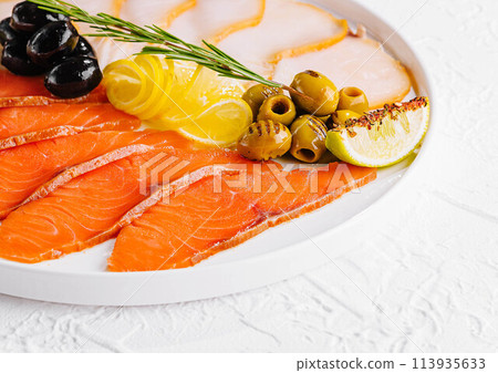 salmon, white fish and olives on plate salmon, white fish and olives on plate 113935633