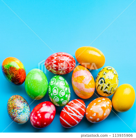 closeup, many beautiful painted Easter eggs as blue background. the concept for good friday, easter monday, spring full moon. copy space on top for text or design. top view, nobody, selective focus 113935906