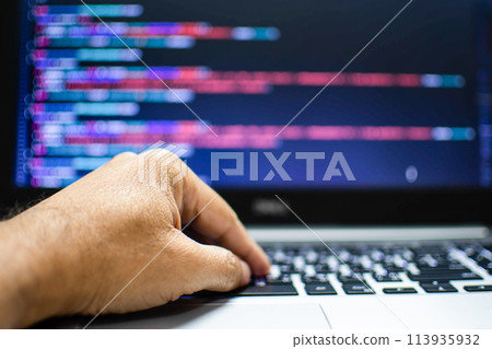 The programmer's hand is writing the source code. Programmers write programs for use with internet business services. The programming code displayed on the laptop screen. Closeup, Blurred background The programmer's hand is writing the source code. Programmers write programs for use with internet business services. The programming code displayed on the laptop screen. Closeup, Blurred background 113935932